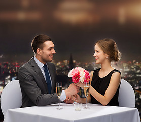 Image showing smiling man giving flower bouquet to woman