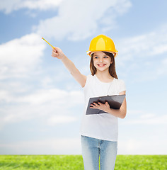 Image showing smiling little girl in hardhat with clipboard