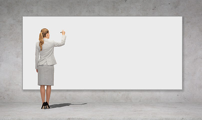 Image showing businesswoman writing with marker on white board