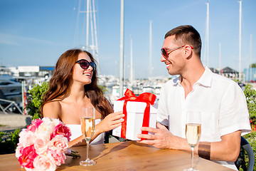 Image showing smiling couple with gift box cafe