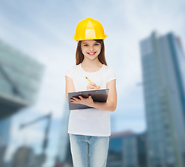 Image showing smiling little girl in hardhat with clipboard