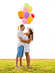 Image showing smiling couple with air balloons outdoors