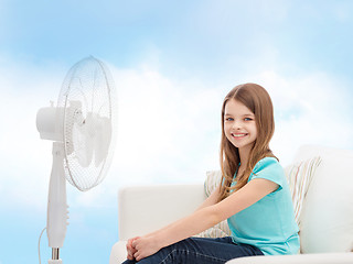 Image showing smiling little girl with big fan at home