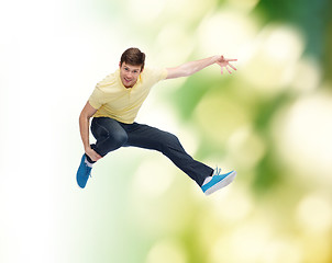 Image showing smiling young man jumping in air