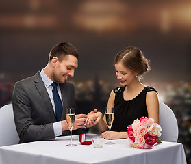 Image showing man proposing to his girlfriend at restaurant