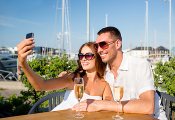 Image showing smiling couple drinking champagne at cafe