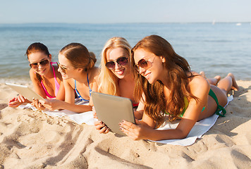 Image showing group of smiling young women with tablets on beach