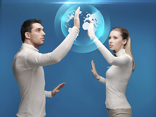 Image showing man and woman working with globe hologram