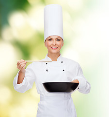 Image showing smiling female chef with pan and spoon