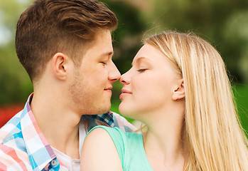 Image showing smiling couple touching noses in park