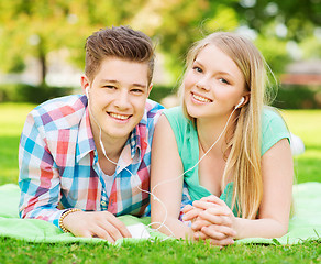 Image showing smiling couple with smartphone and earphones