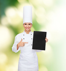 Image showing smiling female chef with black blank paper