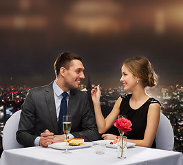 Image showing smiling couple eating dessert at restaurant