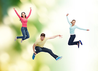 Image showing group of smiling teenagers jumping in air