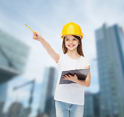 Image showing smiling little girl in hardhat with clipboard