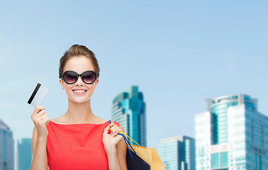 Image showing smiling woman with shopping bags and plastic card