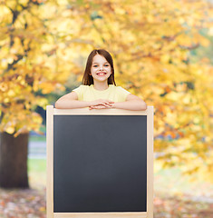 Image showing happy little girl with blank blackboard