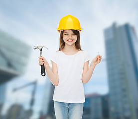 Image showing smiling little girl in hardhat with hammer