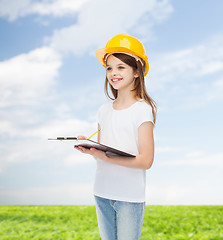 Image showing smiling little girl in hardhat with clipboard