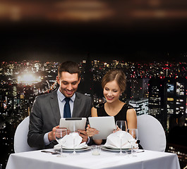 Image showing couple with menus on tablet pc at restaurant