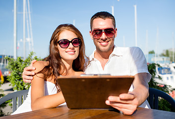 Image showing smiling couple with menu at cafe