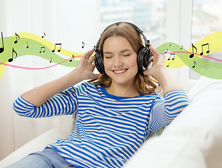 Image showing smiling young girl in headphones at home