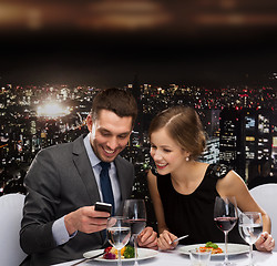 Image showing smiling couple eating main course at restaurant