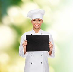 Image showing smiling female chef with black blank paper