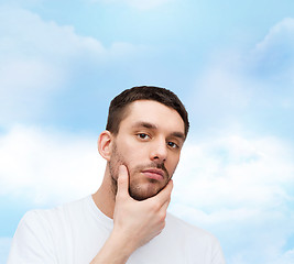 Image showing beautiful calm man touching his face