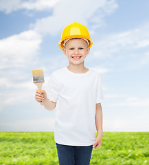 Image showing smiling little boy in helmet with paint brush