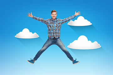 Image showing smiling young man jumping in air