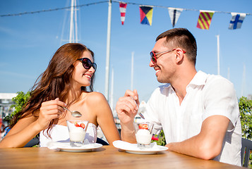 Image showing smiling couple eating dessert at cafe