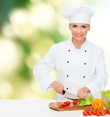 Image showing smiling female chef chopping vegetables