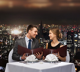 Image showing smiling couple with menus at restaurant