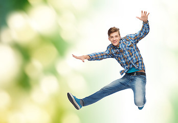 Image showing smiling young man jumping in air