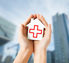 Image showing hands holding paper house with red cross