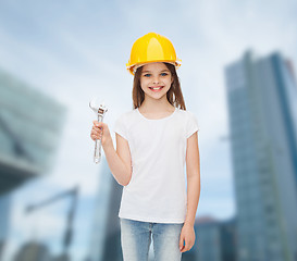 Image showing smiling little girl in hardhat with wrench