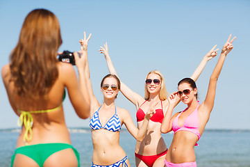 Image showing group of smiling women photographing on beach