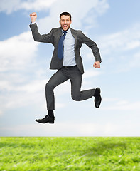 Image showing smiling happy businessman jumping