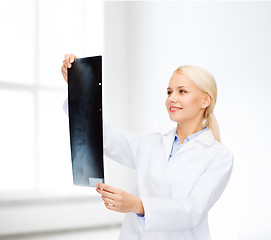 Image showing smiling female doctor looking at x-ray