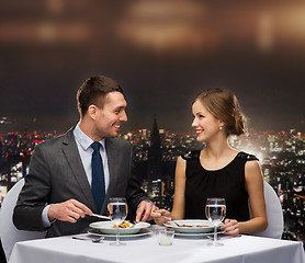 Image showing smiling couple eating main course at restaurant