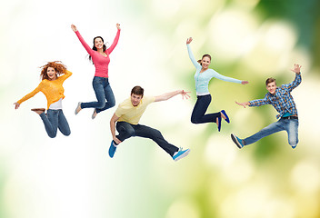 Image showing group of smiling teenagers jumping in air