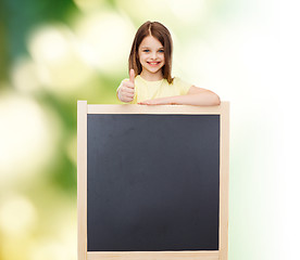 Image showing happy little girl with blank blackboard