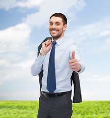 Image showing smiling young businessman showing thumbs up