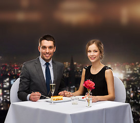 Image showing smiling couple eating dessert at restaurant