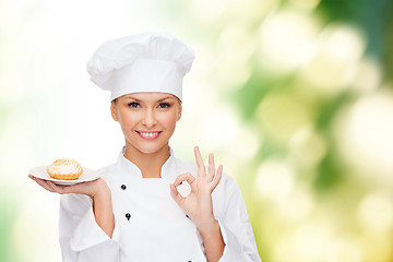 Image showing smiling female chef with cake on plate