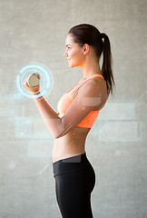 Image showing smiling woman with dumbbells in gym