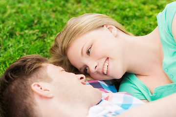 Image showing smiling couple lying on grass in park