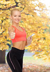 Image showing smiling sporty woman with smartphone