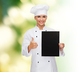 Image showing smiling female chef with black blank paper